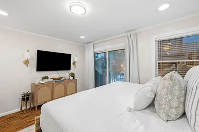 a white bedroom with a bed and a television at Grandy 30A in Inlet Beach