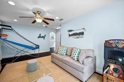 a living room with a couch and a video game at Inlet Love in Inlet Beach