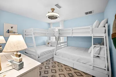 two bunk beds in a bedroom with blue walls at Inlet Love in Inlet Beach