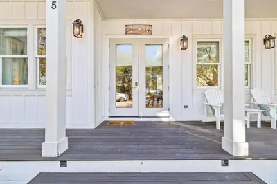 a porch with white columns and a front door at Soakin it Up in Inlet Beach