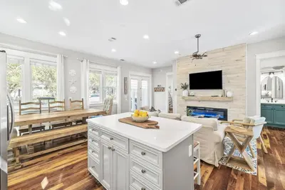 a kitchen and living room with a table and a fireplace at Soakin it Up in Inlet Beach