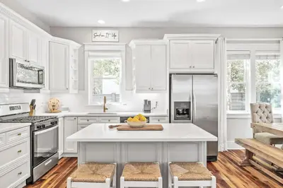 a kitchen with white cabinets and a refrigerator at Soakin it Up in Inlet Beach