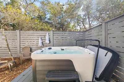 a hot tub in a backyard with a fence at Soakin it Up in Inlet Beach