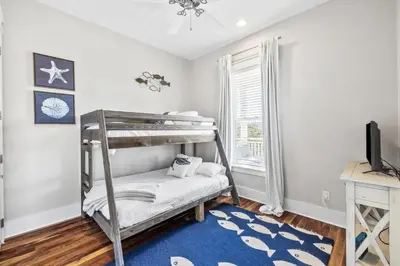a bedroom with a bunk bed with a blue rug at Soakin it Up in Inlet Beach