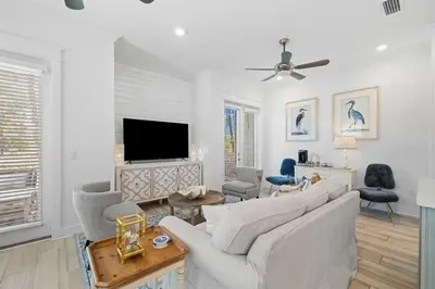 a living room with a white couch and a tv at Heron's Nest in Inlet Beach