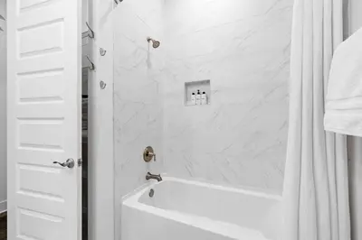 a white bathroom with a tub and a shower at Heron's Nest in Inlet Beach