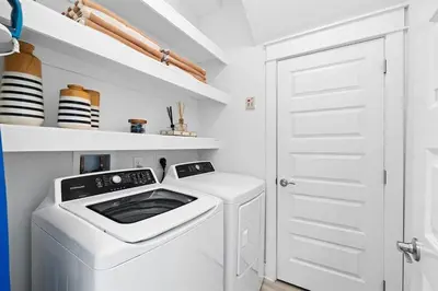 a white laundry room with a washer and dryer at Heron's Nest in Inlet Beach