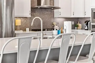 a kitchen with white cabinets and white counter tops at Island Lullaby in Inlet Beach