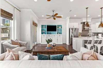 a living room with a couch and a kitchen at Island Lullaby in Inlet Beach