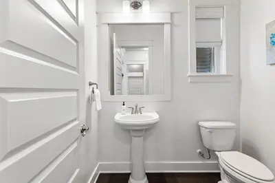 a white bathroom with a sink and a toilet at Island Lullaby in Inlet Beach