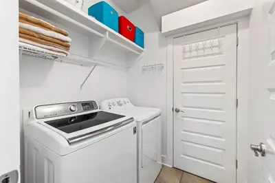a white laundry room with a washer and dryer at Island Lullaby in Inlet Beach