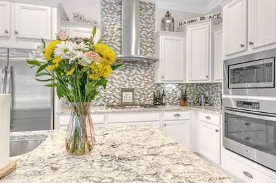a vase of flowers on a counter in a kitchen at Lucky Beach in Inlet Beach