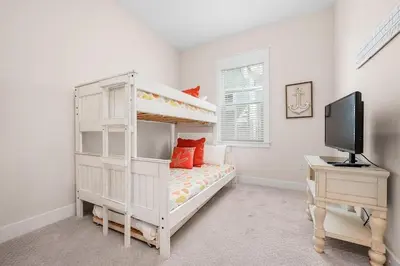 a bedroom with a bunk bed and a desk with a television at Lucky Beach in Inlet Beach