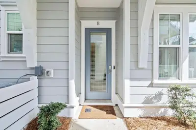 a white house with a blue door at Amen 30A in Inlet Beach