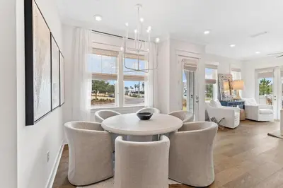 a white dining room with a table and chairs at Journey to 30A in Inlet Beach