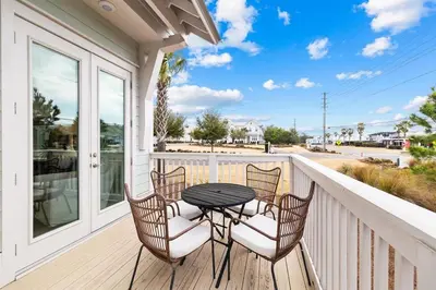 a patio with a table and chairs on a balcony at Journey to 30A in Inlet Beach