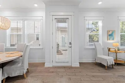 a dining room with a table and chairs and windows at Kelly's Cabana in Inlet Beach