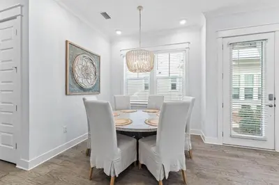 a dining room with a table and chairs and a chandelier at Kelly's Cabana in Inlet Beach