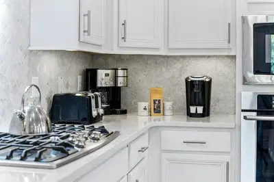 a kitchen with white cabinets and a stove top oven at Kelly's Cabana in Inlet Beach