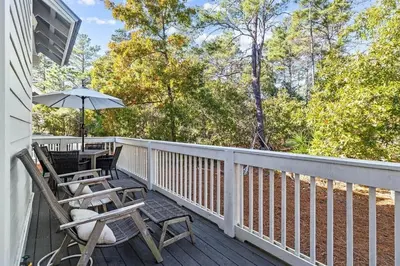 a deck with a table and chairs and an umbrella at Kelly's Cabana in Inlet Beach