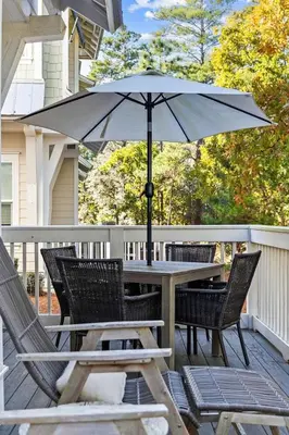 a table and chairs with an umbrella on a deck at Kelly's Cabana in Inlet Beach