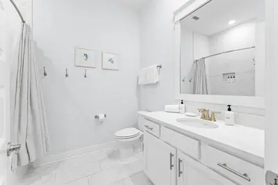 a white bathroom with a sink and a toilet at Kelly's Cabana in Inlet Beach