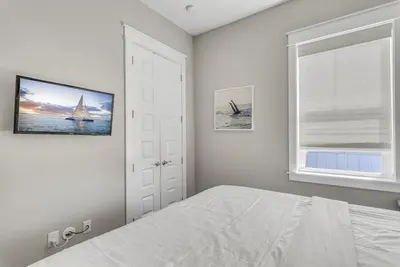 a bedroom with a bed and a window with a sailboat at 30Yay Home in Inlet Beach