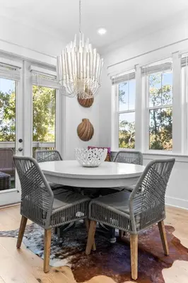 a dining room with a table and chairs and a chandelier at Coco Cottage in Inlet Beach