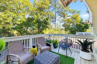 a patio with chairs and a table on a deck at Coco Cottage in Inlet Beach