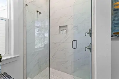 a shower with a glass door in a bathroom at Coco Cottage in Inlet Beach