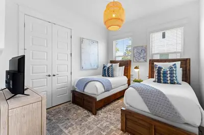 a bedroom with two beds and a tv in it at Coco Cottage in Inlet Beach
