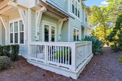 a house with a white fence on a porch at Coco Cottage in Inlet Beach