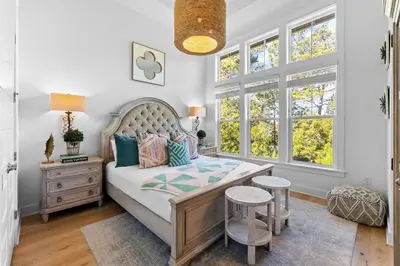 a bedroom with a bed with a table and two stools at Coco Cottage in Inlet Beach