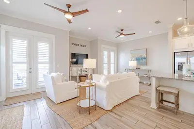 a living room with white furniture and a kitchen at Lala's Beach House in Inlet Beach