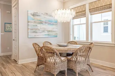 a dining room with a table with chairs and a chandelier at Lala's Beach House in Inlet Beach
