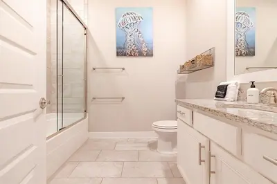 a white bathroom with a shower and a toilet at Lala's Beach House in Inlet Beach