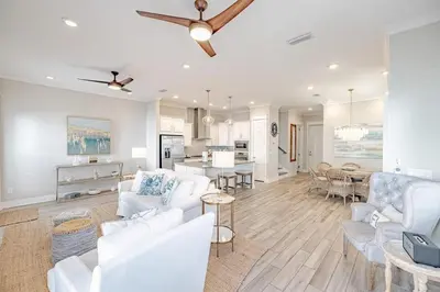 a living room with white furniture and a dining room at Lala's Beach House in Inlet Beach