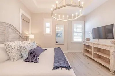 a bedroom with a bed and a flat screen tv at Lala's Beach House in Inlet Beach