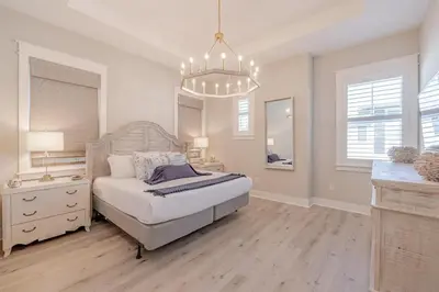 a bedroom with a bed and a chandelier at Lala's Beach House in Inlet Beach