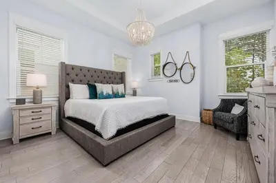 a bedroom with a large bed and a chandelier at Beachwood Hideaway in Inlet Beach