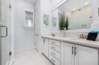 a white bathroom with a sink and a shower at Beachwood Hideaway in Inlet Beach
