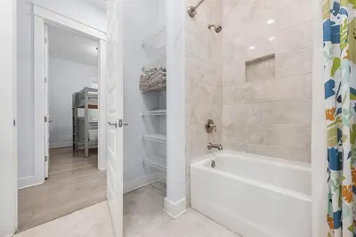 a white bathroom with a tub and a shower at Beachwood Hideaway in Inlet Beach