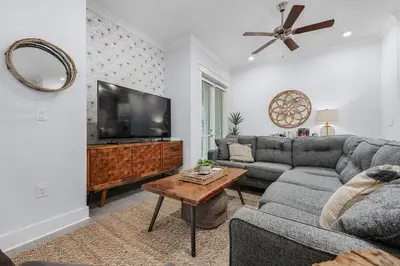 a living room with a couch and a flat screen tv at Beachwood Hideaway in Inlet Beach