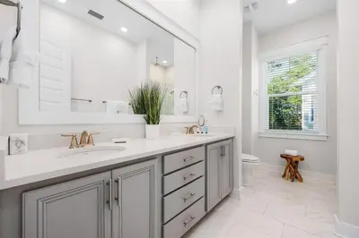 a white bathroom with a sink and a mirror at Forever Grateful in Inlet Beach