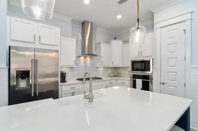 a white kitchen with a sink and a refrigerator at Seas the Day in Inlet Beach