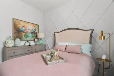 a bedroom with a pink bed with a painting on the wall at Seas the Day in Inlet Beach