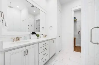 a white bathroom with a sink and a shower at Sea'n is Believe'n in Inlet Beach