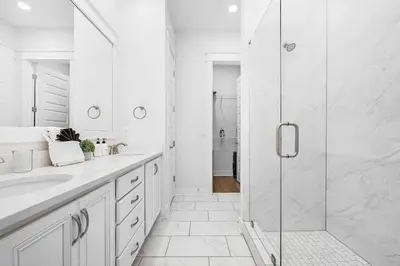 a white bathroom with a shower and a sink at Sea'n is Believe'n in Inlet Beach