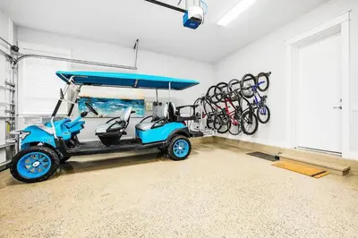 a golf cart parked in a room with bikes on the wall at Sea'n is Believe'n in Inlet Beach