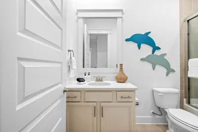 a bathroom with a sink and dolphins on the wall at Just Beachy in Inlet Beach